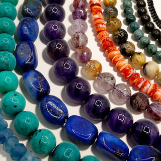 multiple bead strands of various colors on a beige background