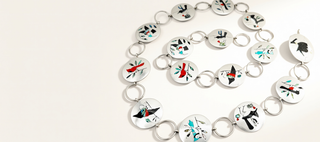 A silver-toned chain bracelet featuring multiple oval links decorated with colorful hand-painted Kuna-style motifs, including black birds, red flowers, and teal details, displayed on a clean white background.
