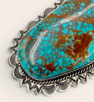 Turquoise stone with silver frame on a white background
