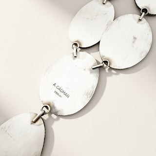silver jewelry with stamp on a beige background