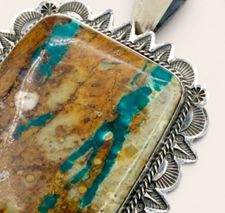 Jewelry with a stone inlay and silver decorative elements on a white background