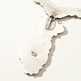 Silver earrings with a detailed design on a white background