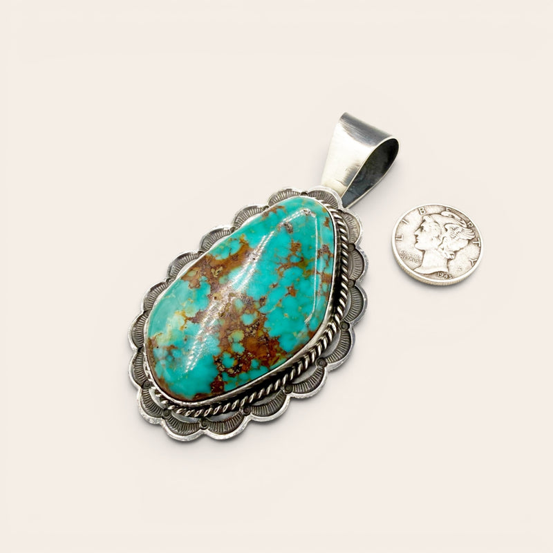 Turquoise pendant with silver frame on a white background