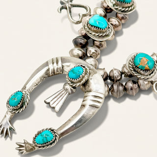 Silver and turquoise beaded necklace on a white background