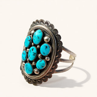 silver ring with turquoise stone clusters on a beige background