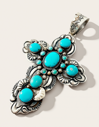 Silver Cross Pendant with turquoise stones on a cream background
