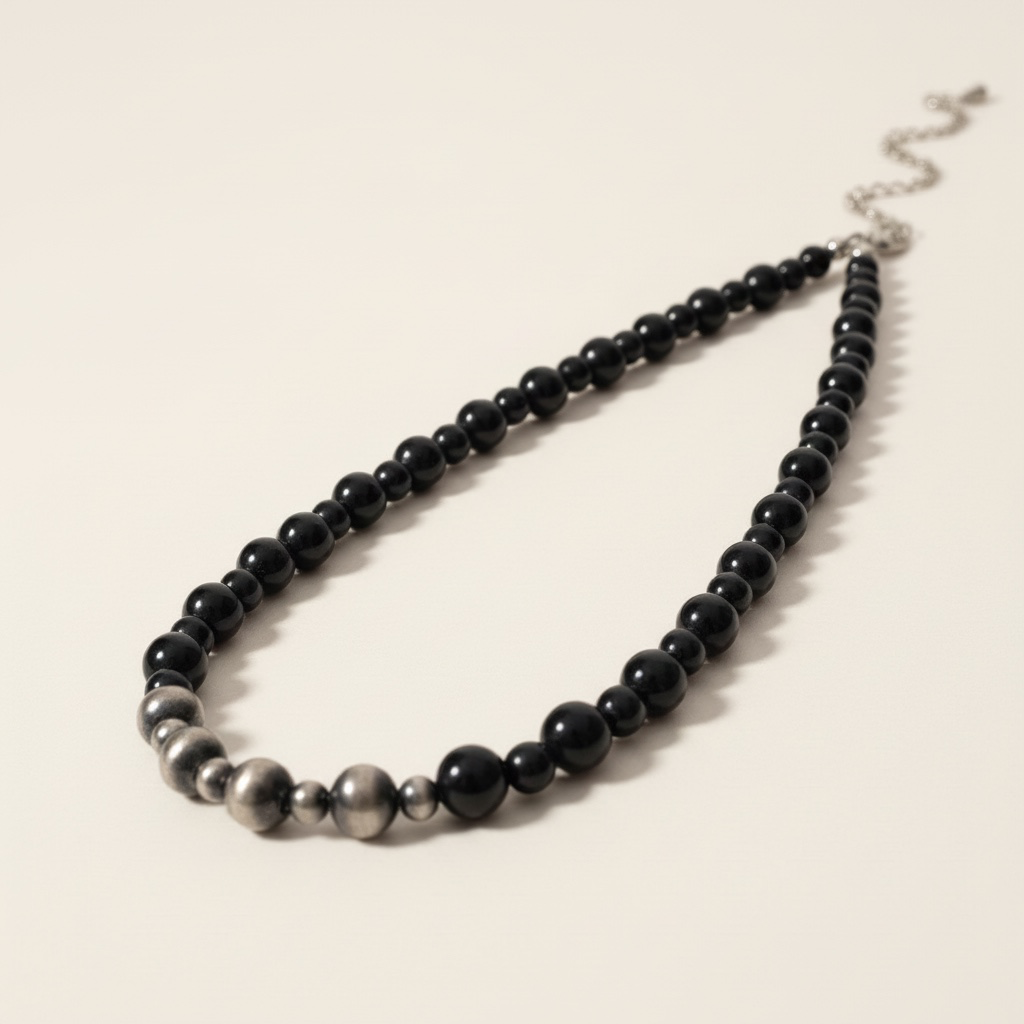 Necklace with black beads on a beige background