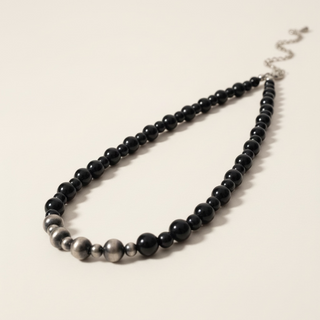 Necklace with black beads on a beige background