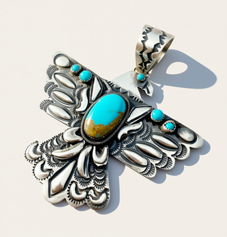 Silver Bird Pendant with turquoise stones on a white background