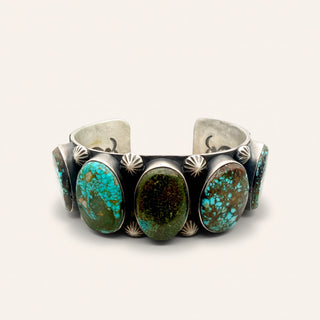 Silver bracelet with turquoise stones on a white background
