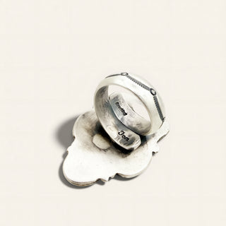 Silver ring with engraved text on a light gray background