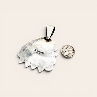 Silver pendant on a white background with the stamp A. Cadman
