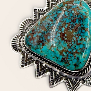 Turquoise stone in a silver frame on a white background