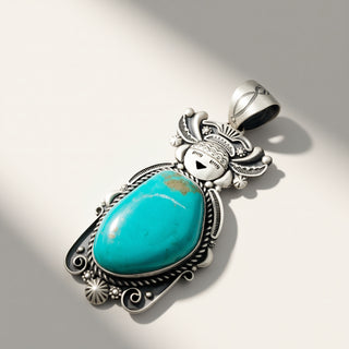 Turquoise pendant with silver decorative elements on a light gray background