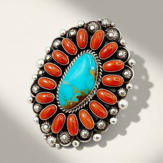 Jewelry with turquoise stone and red stones on a gray background