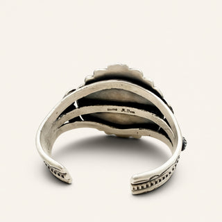 Silver bracelet with intricate design on a white background