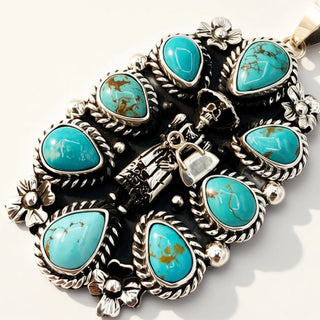 silver pendant with 8 turquoise stones and skeleton motif in the center on a beige background