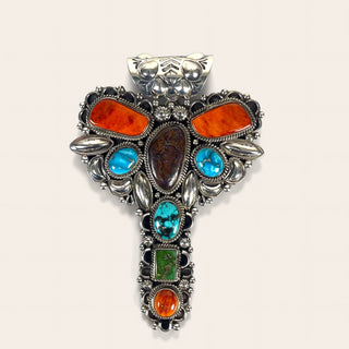 Multicolored gemstone cross pendant on a light pink background