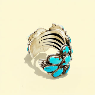 Silver cuff with turquoise stones on a beige background