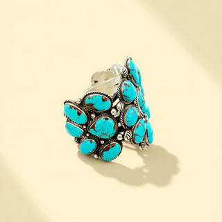 Turquoise stone cuff with silver band on a beige background