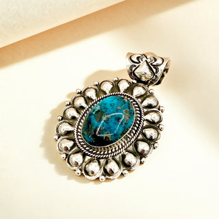 Pendant with blue stone against a beige background
