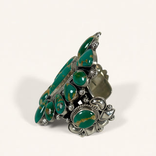 Silver ring with green gemstones on a white background