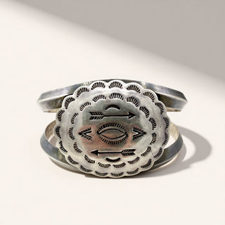 Silver bracelet with intricate designs on a white background