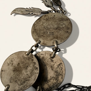 Vintage silver necklace with round pendants and engraved text on a white background