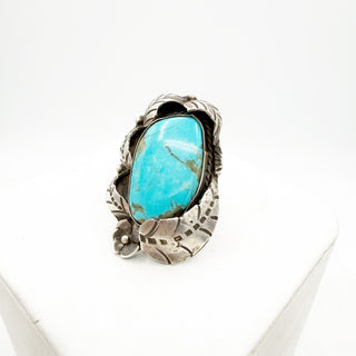 Turquoise stone ring with silver band on a white background