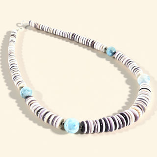 Necklace with striped beads on a beige background
