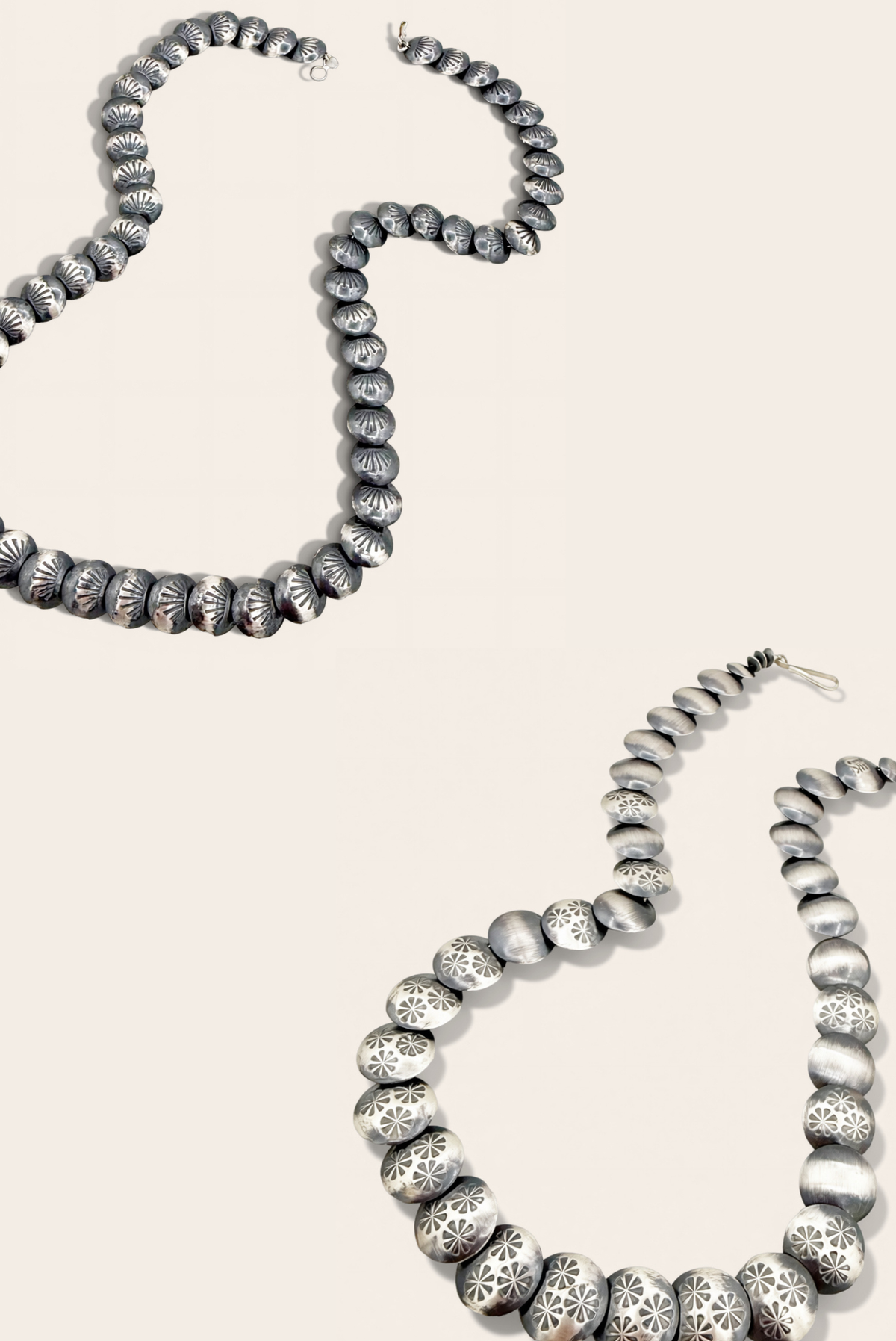 two silver necklaces on a beige background