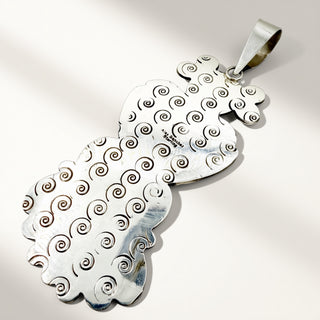 silver pendant on a beige background