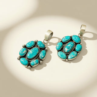Two turquoise stone pendants on a beige background