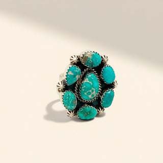 Turquoise ring with silver setting on a beige background