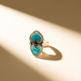 Turquoise ring with silver setting on a beige background