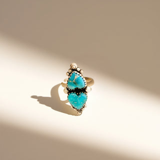 Silver ring with a turquoise stone on a beige background